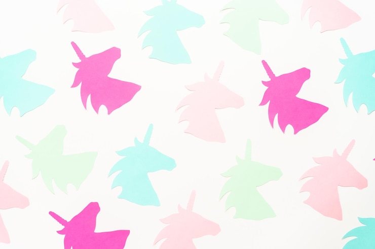 Foto endecha plana. recortes de papel de unicornio de colores sobre un fondo blanco.