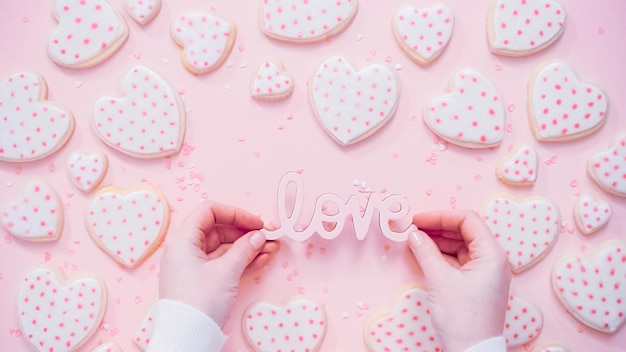 Endecha plana. Signo de amor del día de San Valentín en un fondo rosa.