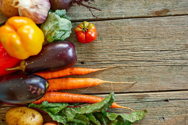 Endecha plana de surtido de verduras frescas, alimentos orgánicos y bio saludables sobre fondo de madera, estilo de mercado rural, productos del jardín, comida vegetariana dietética, alimentación limpia.