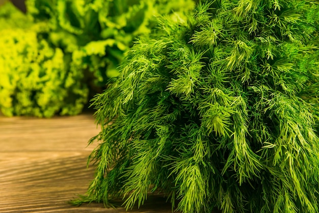 Eneldo verde fresco y hierbas de perejil sobre una mesa de madera rústica Condimento para la cocina Ensalada