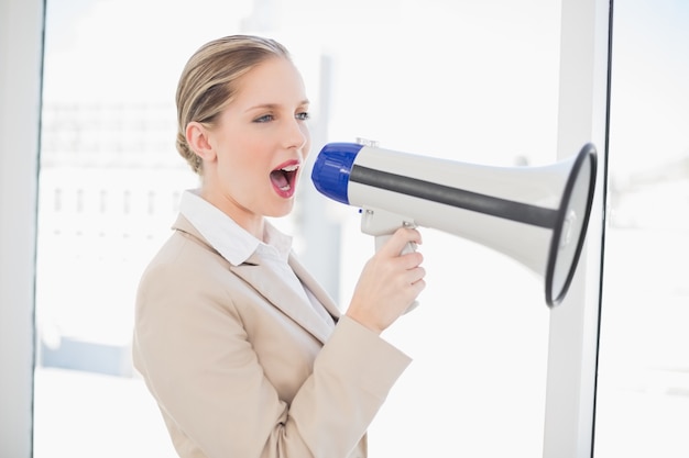 Foto energetic blonde businesswoman shouting in megaphone