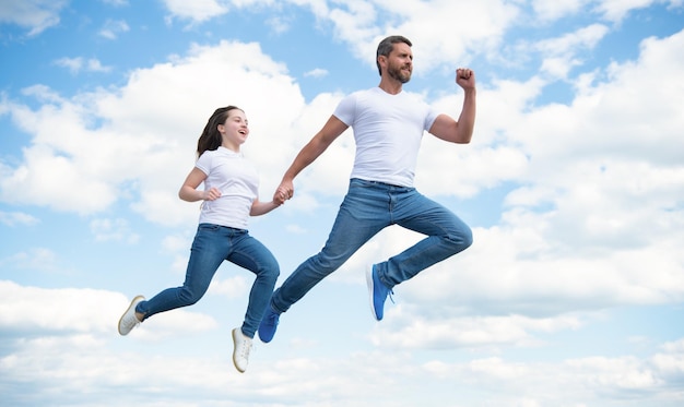 Energetischer Vater und Tochter springen in den Himmel