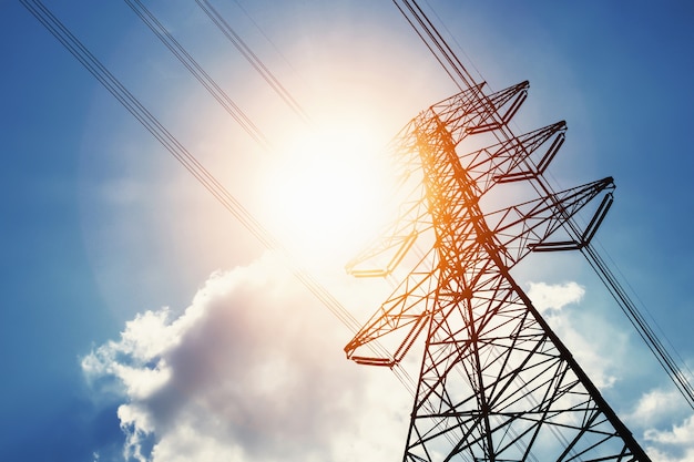 Foto energía de alto voltaje y energía solar con fondo de cielo azul