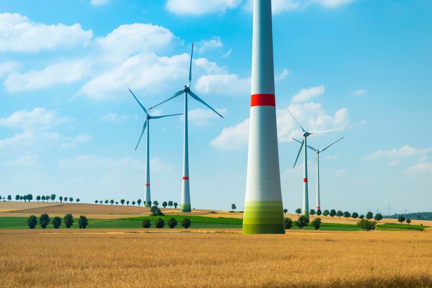 Energía ecológica Turbinas eólicas que generan electricidad Turbinas de viento y campos agrícolas en un día de verano Producción de energía con energía limpia y renovable