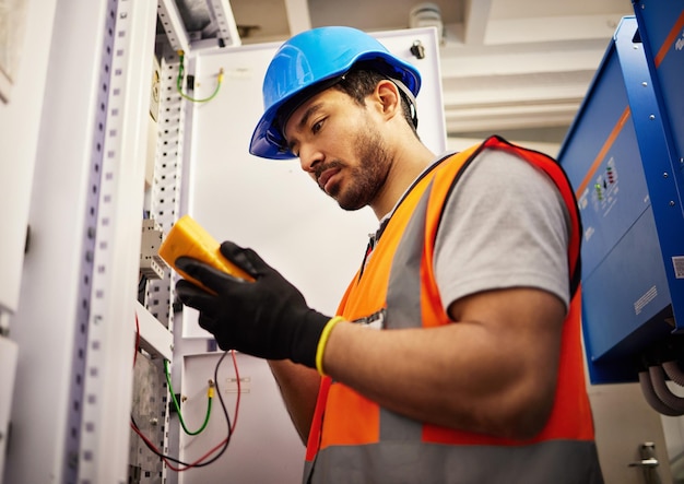 Energia elétrica e inspeção com homem na sala de controle para mecânico de multímetro e segurança Engenharia elétrica e energia com técnico e verificação de circuito e manutenção do gerador