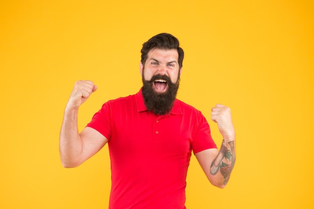 Energía interior Motivado para el éxito Hombre feliz mostrar gesto de éxito fondo amarillo Victoria y éxito Hombre barbudo en estilo casual celebrando Felicidad y alegría Ganador y victoria Chico alegre