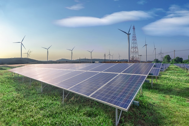 Energia renovável, painéis solares e turbinas eólicas na grama verde no céu azul