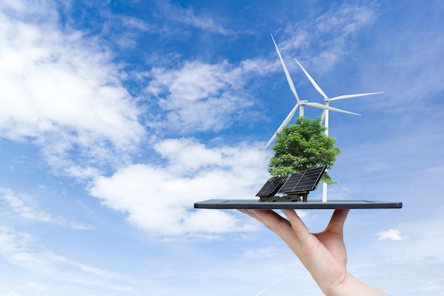 Foto energia solar do sistema ecológico da cidade na mão segurando o tablet