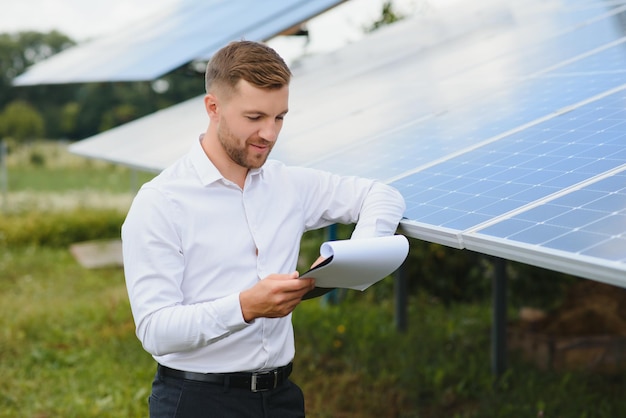 Energia solar Jovem empresário perto dos painéis solares para usinas de energia