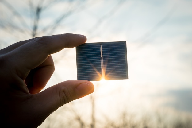 Foto energia verde, célula solar fotovoltaica com a mão