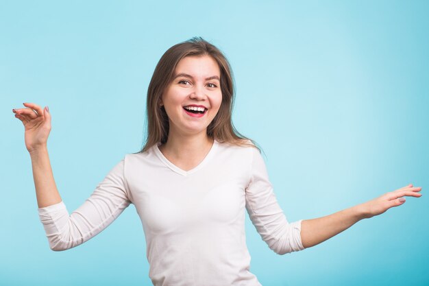 Energiemädchen tanzt auf blauer Wand