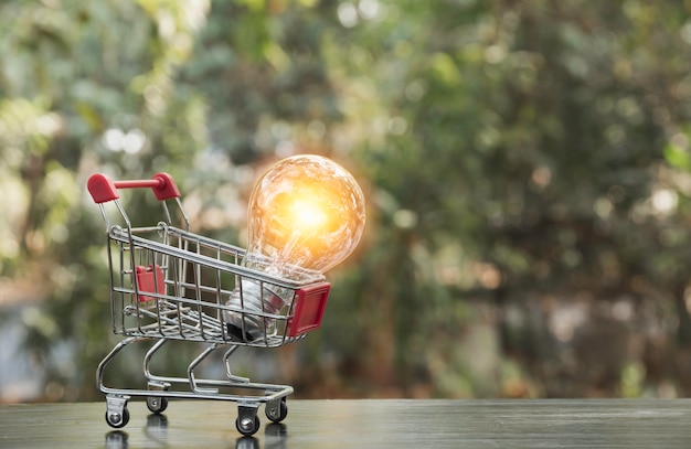 Energiesparende Glühlampe mit Warenkorb Finanz- und Einkaufskonzept