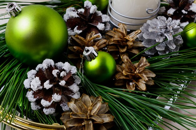 Enfeite de Natal verde e pinhas decoradas com neve