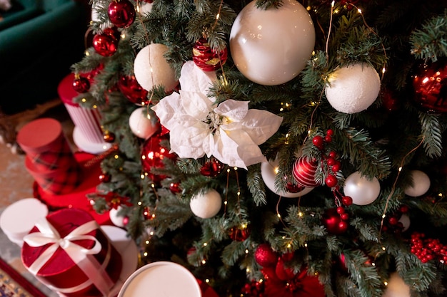 Enfeites de natal coloridos pendurados na árvore de natal Decoração de bolas coloridas no fundo verde da árvore de natal feliz ano novo celebrações de inverno