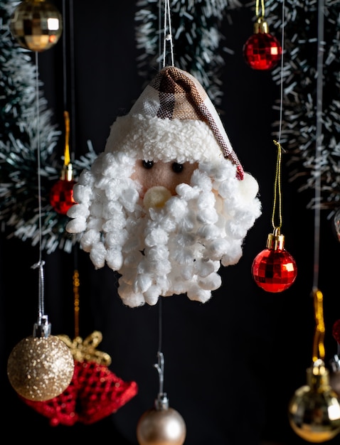 Enfeites de Natal, com destaque para o Papai Noel e o sino de Natal entre bolas vermelhas e douradas.