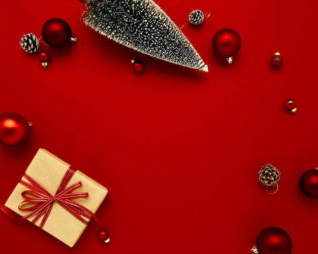 Enfeites de Natal de caixa de presente de composição plana leiga em fundo vermelho para férias. Vista superior com espaço de cópia