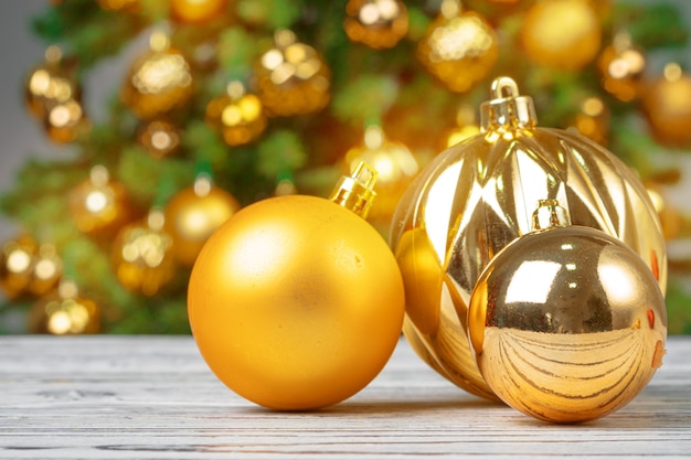 Foto enfeites de natal na mesa de madeira contra a árvore de natal decorada turva