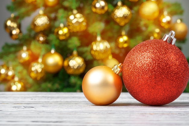 Enfeites de Natal na mesa de madeira contra o fundo desfocado da árvore de Natal decorada