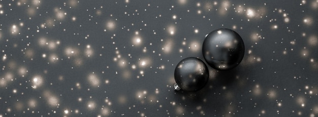Enfeites de Natal pretos com brilho de neve brilham cartão de férias de inverno de marca de luxo