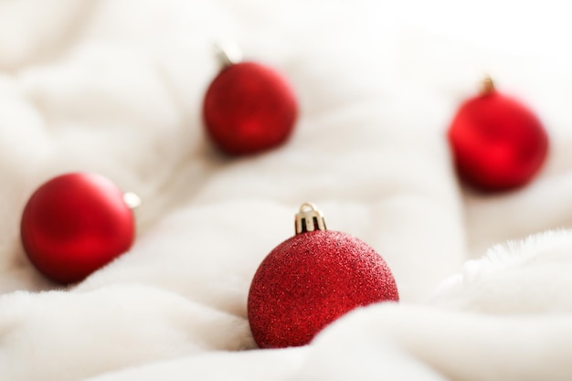 Enfeites de Natal vermelhos em pano de fundo de pele branca e fofa fundo de design de férias de inverno de luxo