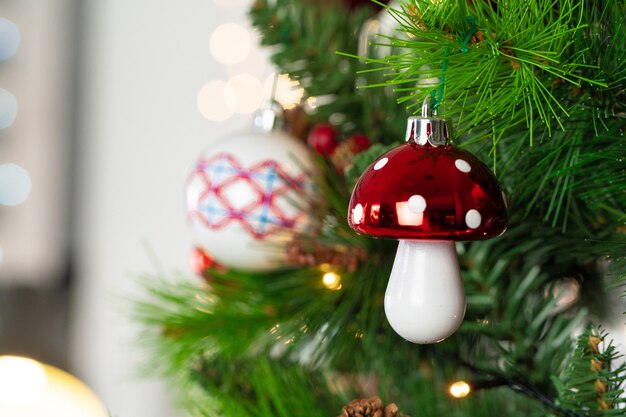 Enfeites vermelhos e brancos pendurados em uma árvore de Natal close-up