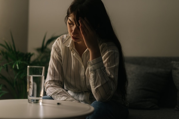 Enferma hermosa joven sentada frente a una mesa con una tableta