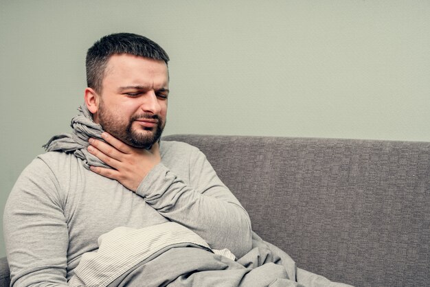 Enfermedad. Anímate en casa. Un joven está enfermo, recibe tratamiento en casa. Se sopla la nariz en una servilleta, secreción nasal. Infección, epidemia, portador de bacilos.