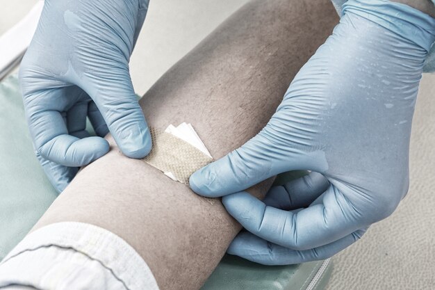 Foto enfermeira colhendo amostra de sangue para fazer um teste em laboratório de tonificação azul