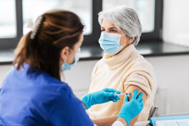 Enfermeira com seringa a dar uma injecção a uma mulher