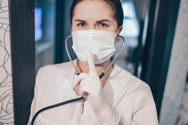 Enfermeira de médico mulher usando máscara protetora e estetoscópio para verificar a respiração, prevenção de vírus corona, higiene para parar de espalhar o coronavírus. Evite contaminar o conceito Covid-19 do vírus Corona