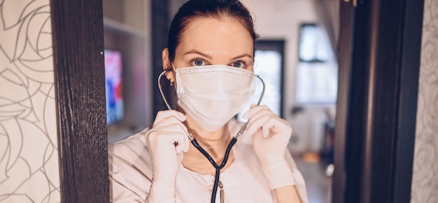 Enfermeira de médico mulher usando máscara protetora e estetoscópio para verificar a respiração, prevenção de vírus corona, higiene para parar de espalhar o coronavírus. Evite contaminar o conceito Covid-19 do vírus Corona