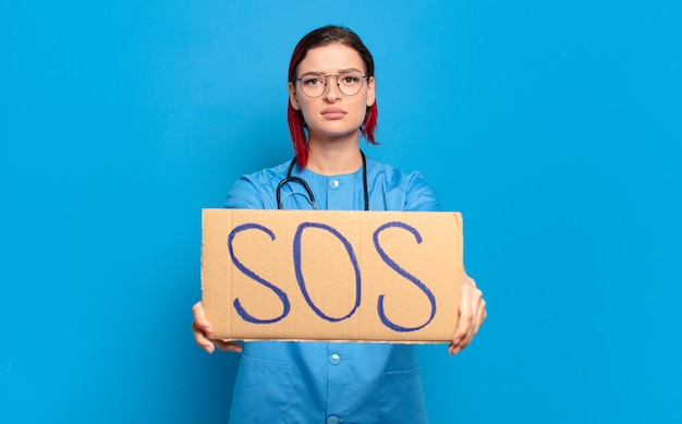 Enfermeira descolada de cabelo ruivo segurando banner SOS