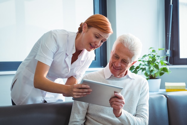 Enfermeira e homem sênior usando um tablet digital