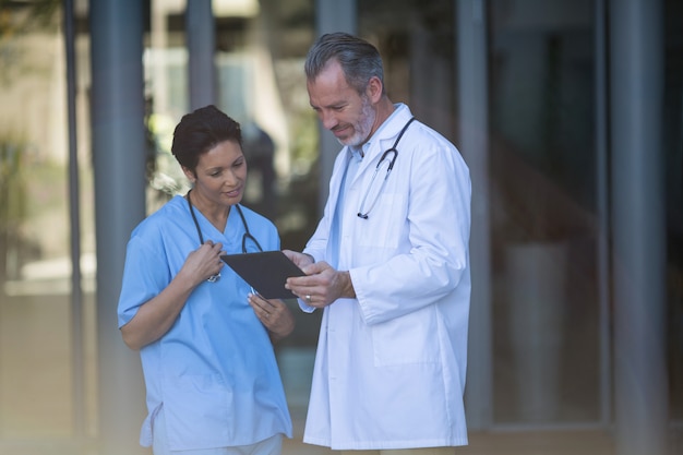 Enfermeira e médico discutindo sobre tablet digital