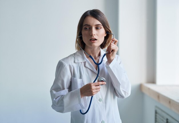 Enfermeira em um vestido médico e um estetoscópio em volta do retrato do sorriso do pescoço