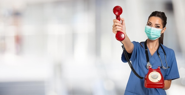 Enfermeira fazendo uma ligação com um telefone vintage covid e conceito de coronavírus Fundo amplo com grande espaço de cópia