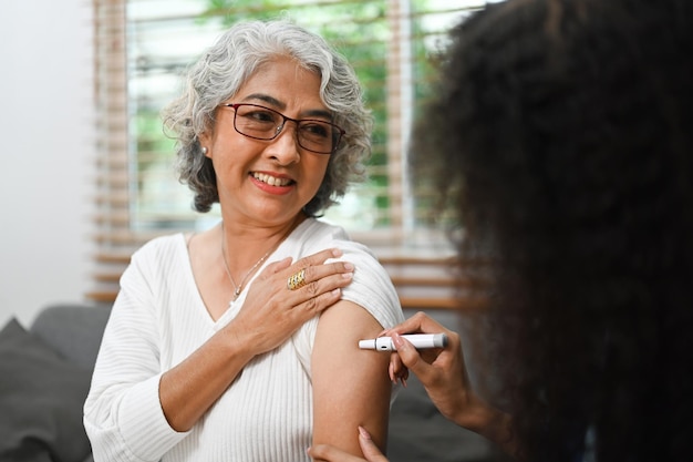 Enfermeira injetando insulina na parte superior do braço de um paciente idoso diabético Conceito de diabetes e cuidados de saúde