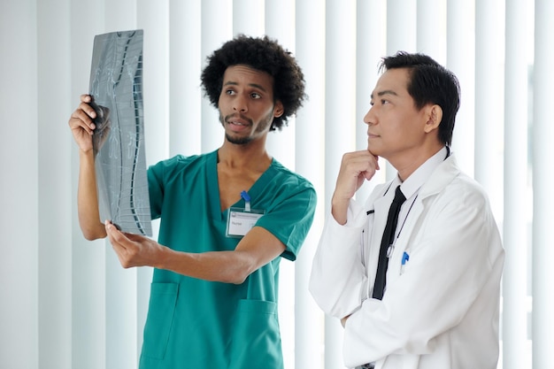 Enfermeira mostrando radiografia da coluna do paciente ao médico