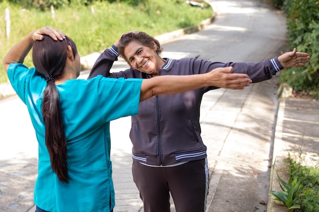 Enfermeira orientando uma idosa em exercícios para fortalecer o pescoço e melhorar a flexibilidade