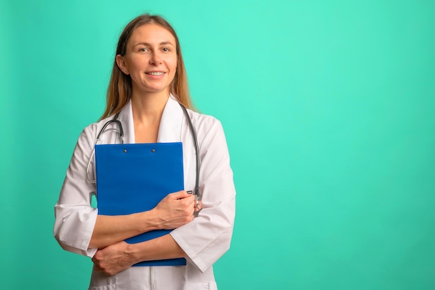 Enfermeira ou médica jovem e atraente com um jaleco branco com uma pasta no fundo