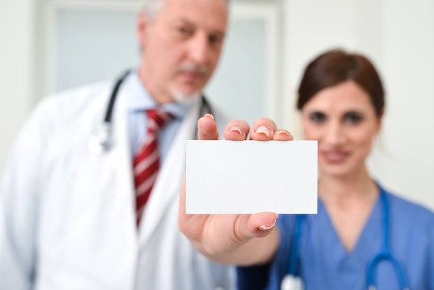 Foto enfermeira segurando um cartão em branco