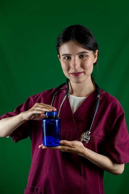 Enfermeira segurando um frasco de remédio nas mãos isolado em um fundo de estúdio monocromático