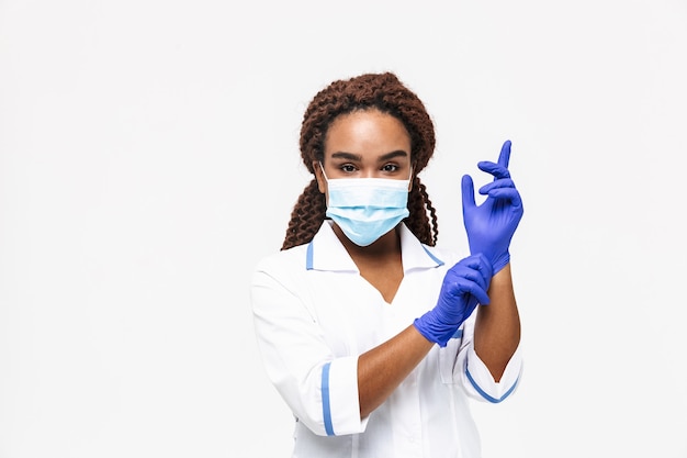 enfermeira usando máscara médica e luvas descartáveis isoladas contra uma parede branca