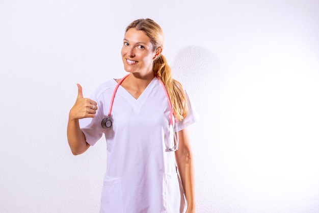 Enfermeira vestida com vestido de hospital e estetoscópio apontando o conceito sanitário Fundo branco e espaço de cópia