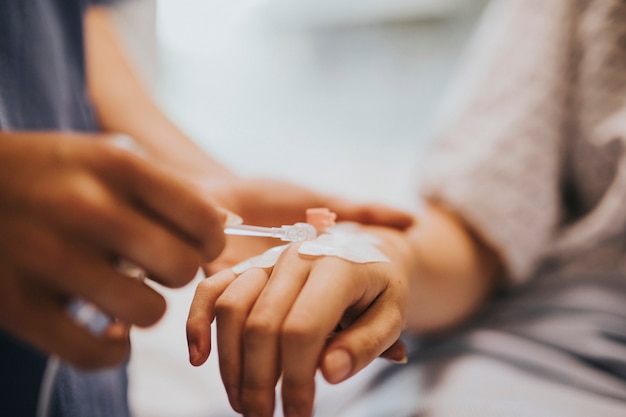 Enfermera aplicando un goteo intravenoso a un paciente.