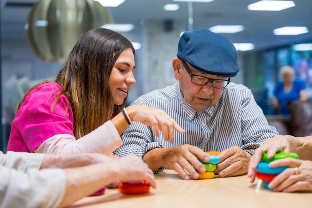 Enfermera asesorando a un anciano jugando juegos de habilidad