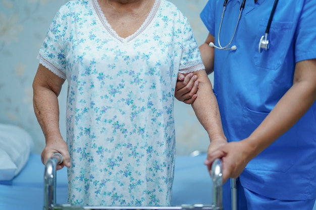 Enfermera asiática, fisioterapeuta, doctora, ayuda y ayuda a una anciana anciana paciente.