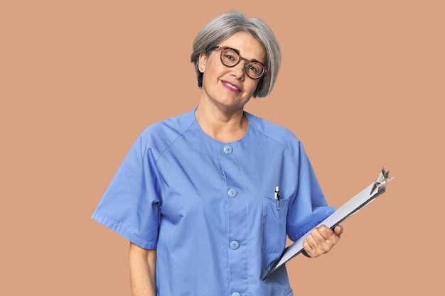 Enfermera caucásica de mediana edad que sostiene el informe feliz sonriente y alegre