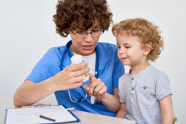 Enfermera dando vitaminas al niño pequeño