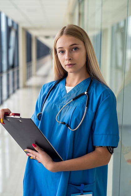 Una enfermera experimentada revisa documentos en una tableta en el camino a la sala de pacientes Concepto de medicina